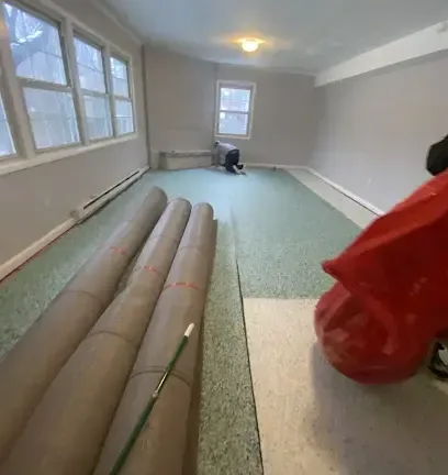 Soaked carpet rolled back for extraction in a flooded room